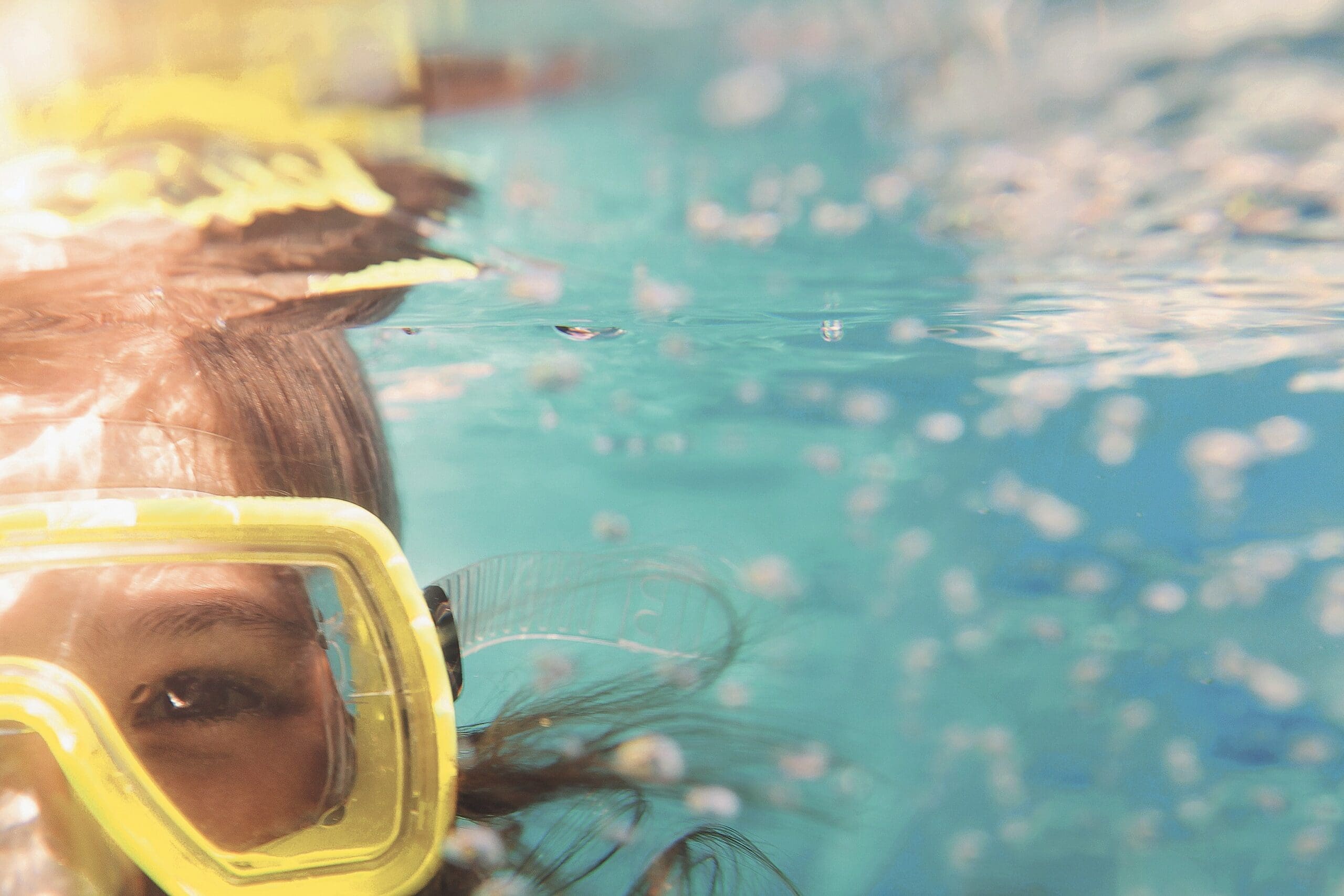 Mädchen mit Taucherbrille im Poolwasser